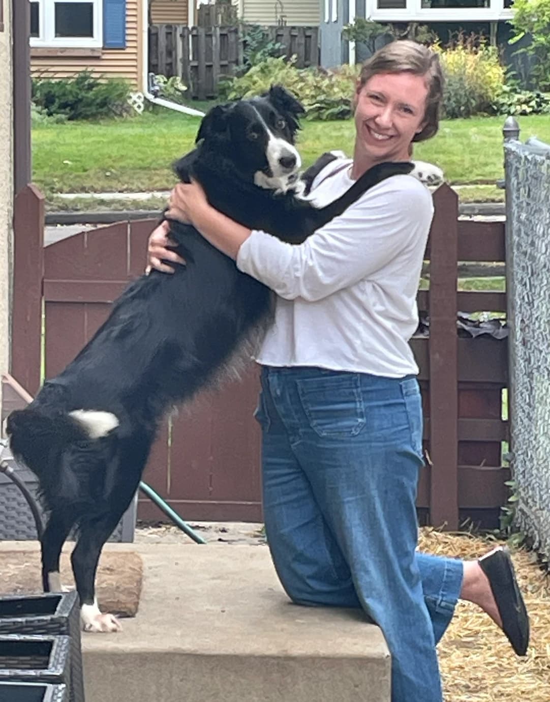 Liane greeting Ludo, who is jumping up to say hello on a porch step